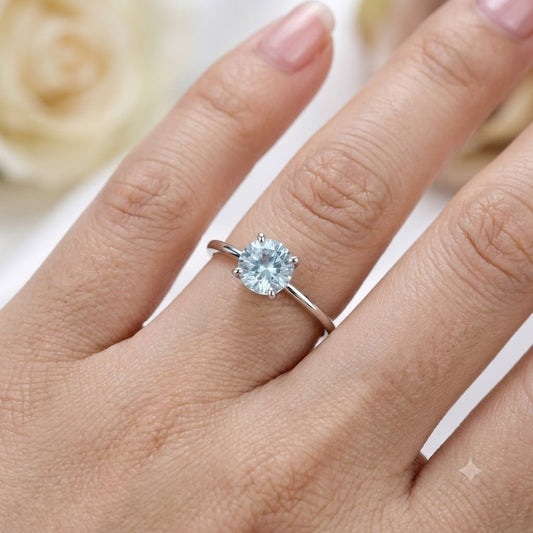Solitaire Blue Topaz Ring crafted in 925 Sterling Silver with a round cut sky blue gemstone in a four-prong setting.