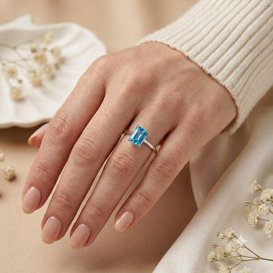 Emerald Cut Blue Topaz Ring crafted in 925 Sterling Silver with a Swiss Blue emerald cut gemstone in a four-prong solitaire setting.