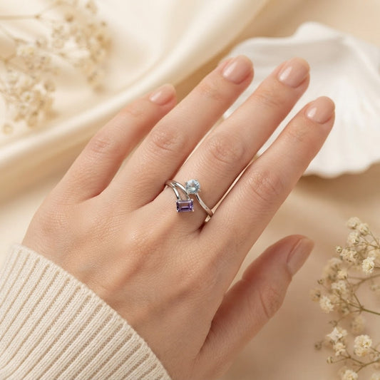 Open Amethyst and Blue Topaz Ring crafted in 925 Sterling Silver featuring an emerald cut Amethyst and pear cut Blue Topaz gemstone.