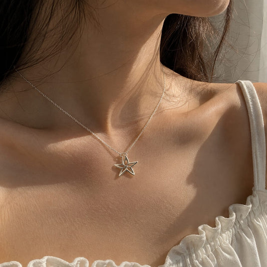 925 Sterling Silver Star Cutout Charm Pendant on Soft Textured Fabric Background