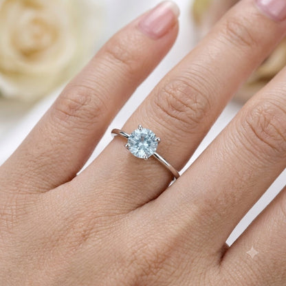 Solitaire Blue Topaz Ring crafted in 925 Sterling Silver with a round cut sky blue gemstone in a four-prong setting.