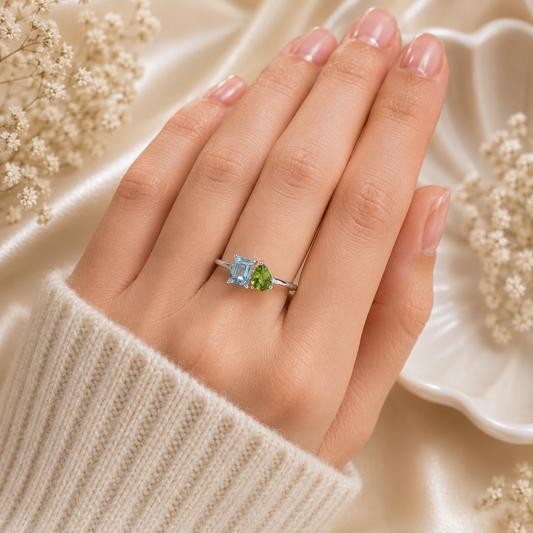 Twin Blue Topaz Ring crafted in 925 Sterling Silver featuring an emerald cut Blue Topaz and pear cut green accent gemstone.