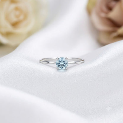 Solitaire Blue Topaz Ring crafted in 925 Sterling Silver with a round cut sky blue gemstone in a four-prong setting.