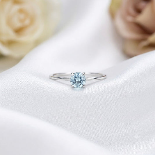 Solitaire Blue Topaz Ring crafted in 925 Sterling Silver with a round cut sky blue gemstone in a four-prong setting.