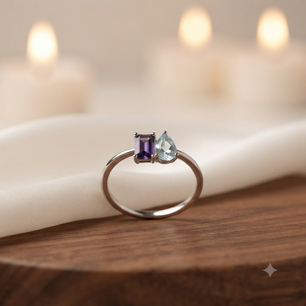 Twin Amethyst and Blue Topaz Ring crafted in 925 Sterling Silver featuring an emerald cut Amethyst and heart cut Blue Topaz gemstone.