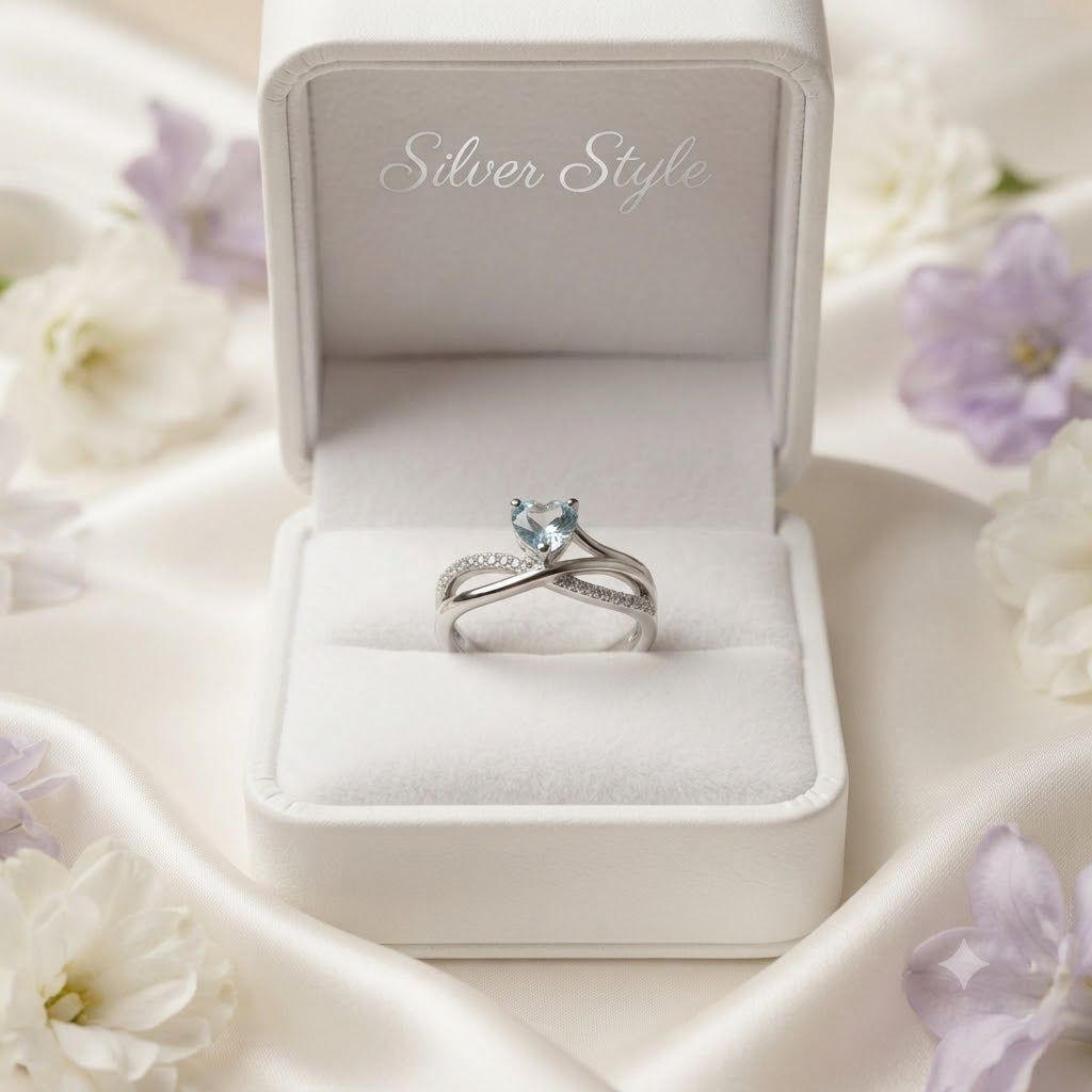 Heart Blue Topaz Ring crafted in 925 Sterling Silver with a heart cut sky blue gemstone and crossover pavé band.