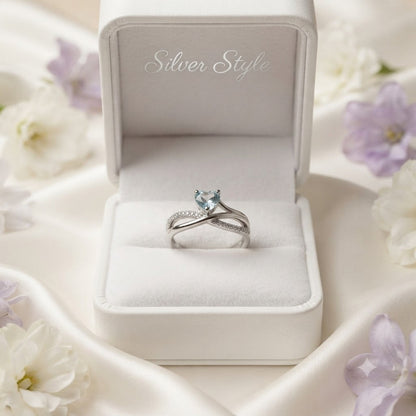 Heart Blue Topaz Ring crafted in 925 Sterling Silver with a heart cut sky blue gemstone and crossover pavé band.
