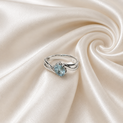 Oval Blue Topaz Ring crafted in 925 Sterling Silver with an oval cut sky blue gemstone in a four-prong setting and split shank design.