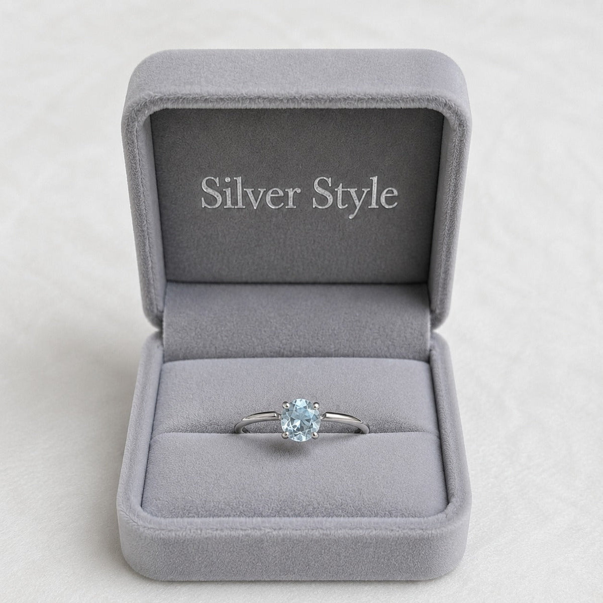 Solitaire Blue Topaz Ring crafted in 925 Sterling Silver with a round cut sky blue gemstone in a four-prong setting.