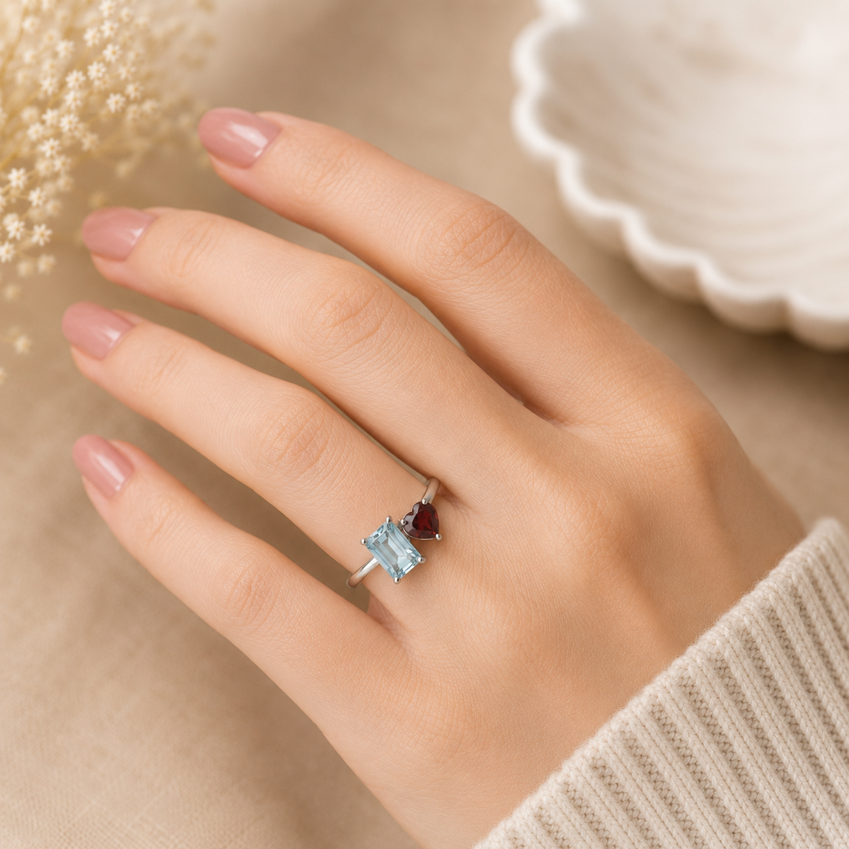 Twin Blue Topaz and Garnet Ring crafted in 925 Sterling Silver featuring an emerald cut Blue Topaz and heart cut Garnet gemstone.