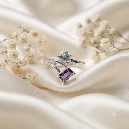 Open Amethyst and Blue Topaz Ring crafted in 925 Sterling Silver featuring an emerald cut Amethyst and pear cut Blue Topaz gemstone.