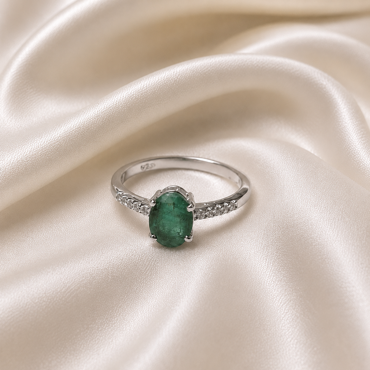 Oval Emerald Solitaire Ring crafted in 925 Sterling Silver with a green oval cut Emerald gemstone and side accents.