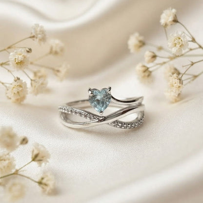 Heart Blue Topaz Ring crafted in 925 Sterling Silver with a heart cut sky blue gemstone and crossover pavé band.