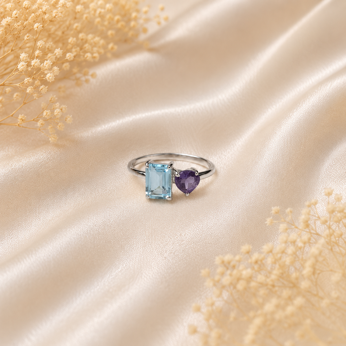 Open Blue Topaz Ring crafted in 925 Sterling Silver with an emerald cut sky blue Blue Topaz and heart-shaped purple accent gemstone.