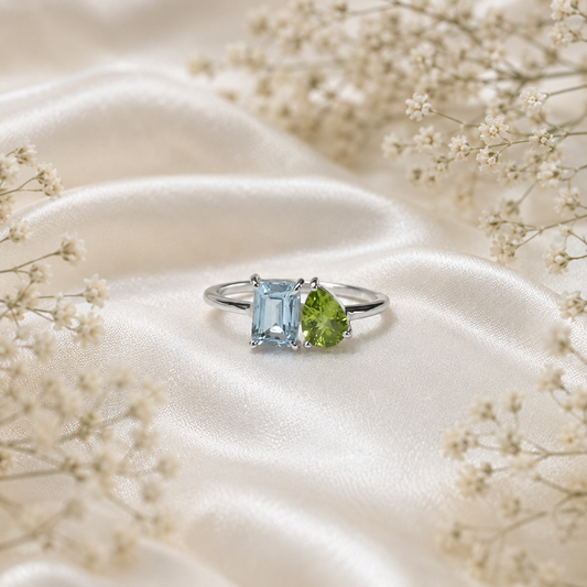 Twin Blue Topaz Ring crafted in 925 Sterling Silver featuring an emerald cut Blue Topaz and pear cut green accent gemstone.