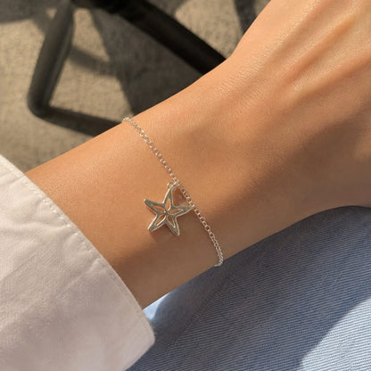 925 Sterling Silver Star Cutout Charm Pendant on Soft Textured Fabric Background