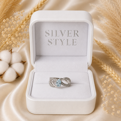 Oval Blue Topaz Ring crafted in 925 Sterling Silver with an oval cut sky blue gemstone and intertwined pavé accented band.
