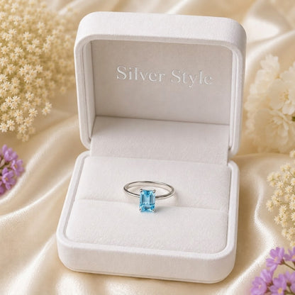 Emerald Cut Blue Topaz Ring crafted in 925 Sterling Silver with a Swiss Blue emerald cut gemstone in a four-prong solitaire setting.