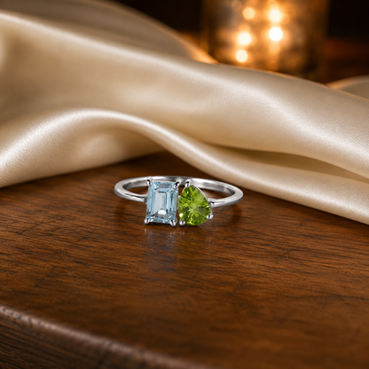 Twin Blue Topaz Ring crafted in 925 Sterling Silver featuring an emerald cut Blue Topaz and pear cut green accent gemstone.