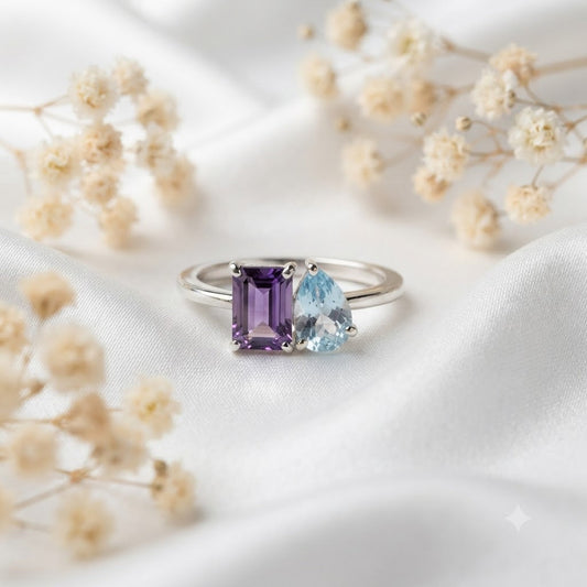 Twin Amethyst and Blue Topaz Ring crafted in 925 Sterling Silver featuring an emerald cut Amethyst and heart cut Blue Topaz gemstone.