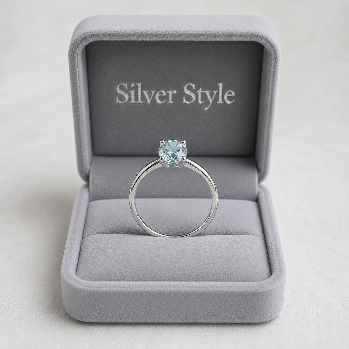 Solitaire Blue Topaz Ring crafted in 925 Sterling Silver with a round cut sky blue gemstone in a four-prong setting.