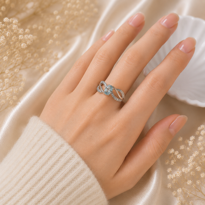 Oval Blue Topaz Ring crafted in 925 Sterling Silver with an oval cut sky blue gemstone and intertwined pavé accented band.