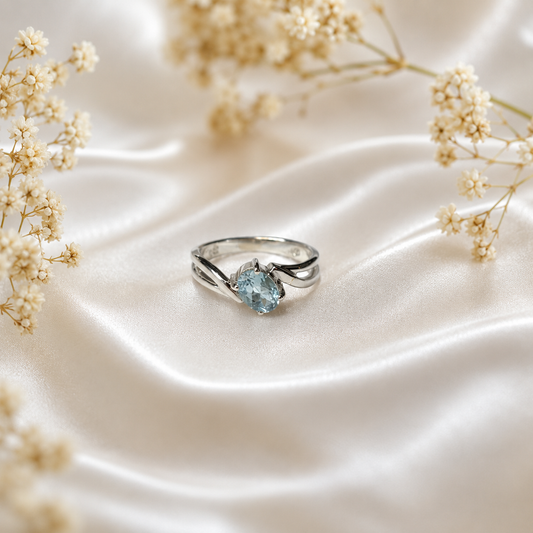 Oval Blue Topaz Ring crafted in 925 Sterling Silver with an oval cut sky blue gemstone in a four-prong setting and split shank design.
